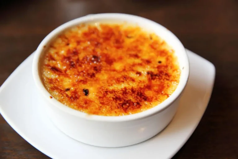 Crème brûlée with a caramelized sugar crust in a white ramekin