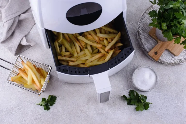 Freshly cooked frozen fries served from an air fryer on a kitchen counter.