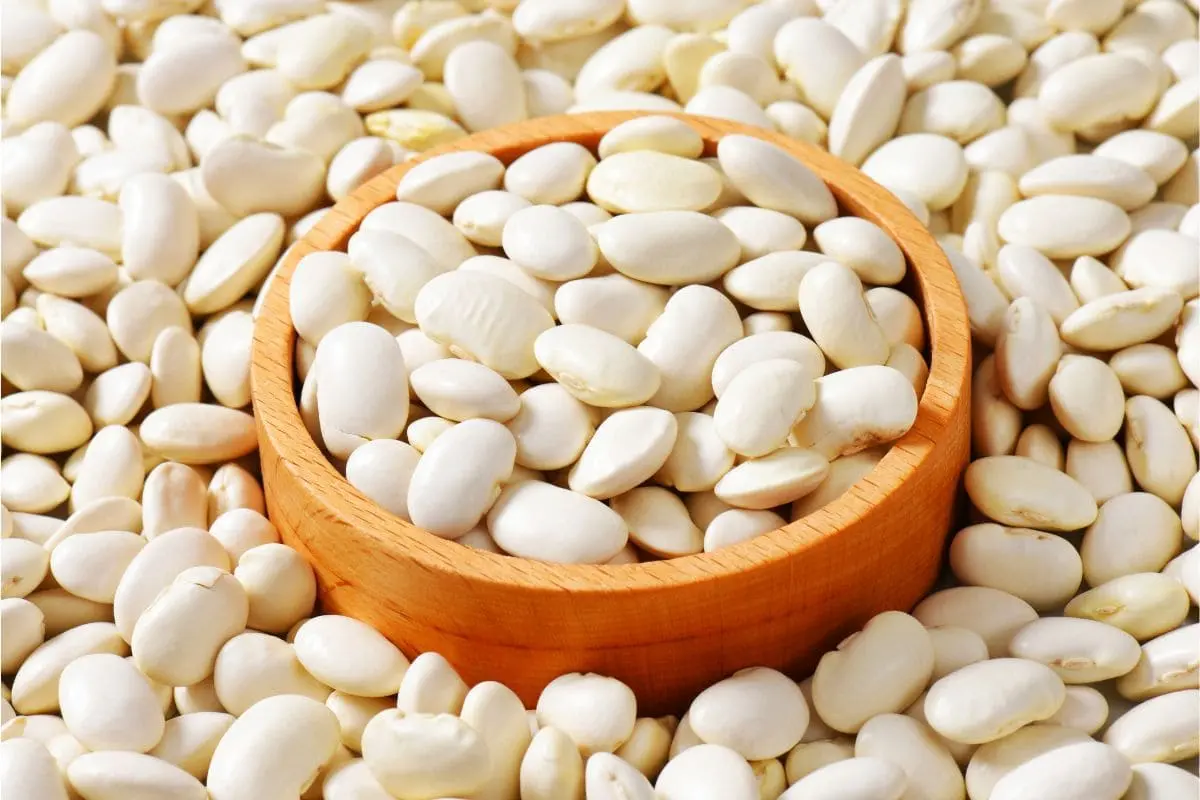 Bowl of shelled white butter beans spread on a table