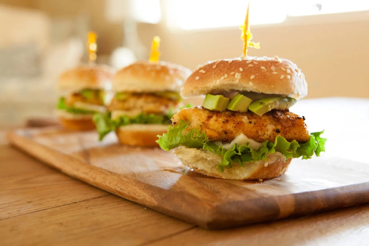 Delicious Chicken Sliders with Fresh Avocado and Lettuce on a Wooden Board