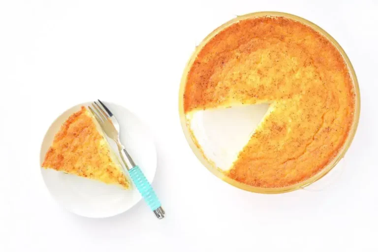 Golden-baked Egg Pie with one slice served on a white plate, complete with a fork on a clean white background.