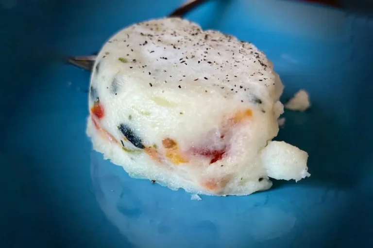 Egg white bites with colorful vegetables against a vibrant blue background, perfect for a healthy breakfast or snack.