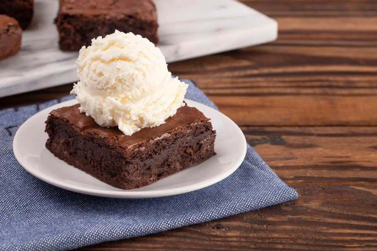 Rich chocolate brownie topped with a scoop of vanilla ice cream.