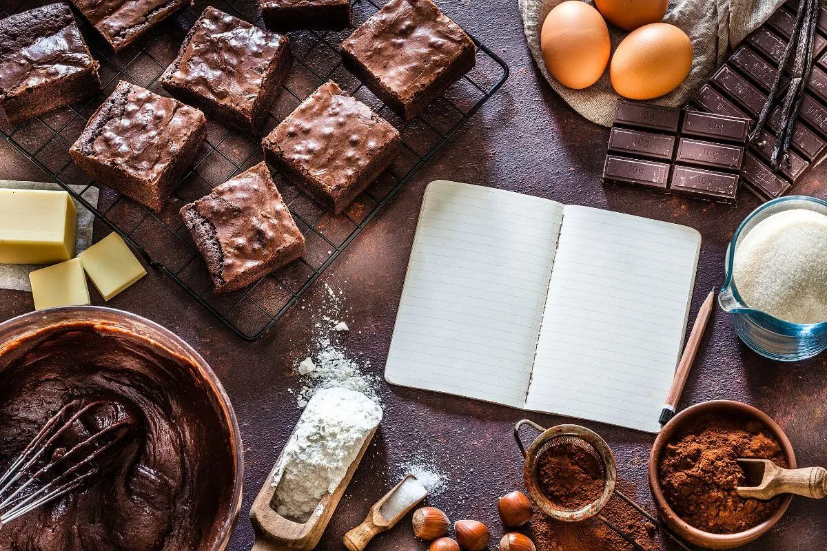 Homemade brownie recipe ingredients and freshly baked brownies on a cooling rack.